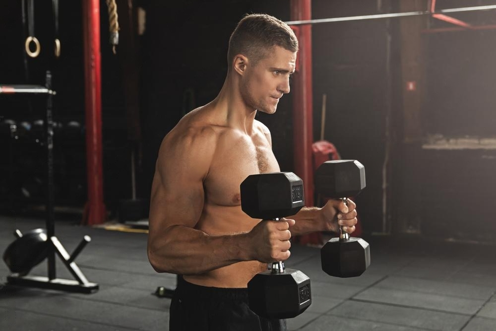 A guy with good physique doing hammer curl workout.