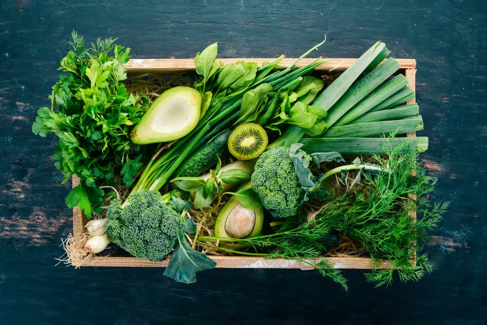 A wooden crate filled with an array of fresh vegetables for plant-based diet, highlighting their natural colors and textures in a wholesome display.